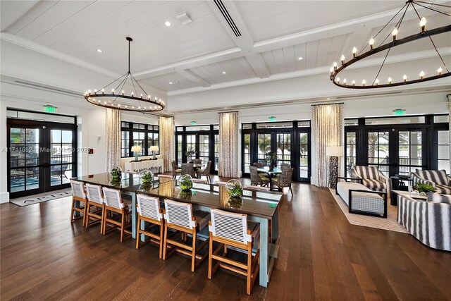 living room featuring french doors, crown molding, a chandelier, lofted ceiling with beams, and dark hardwood / wood-style flooring