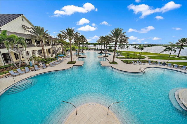 view of swimming pool featuring a patio and a water view