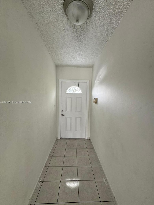 entryway featuring a textured ceiling and light tile patterned flooring