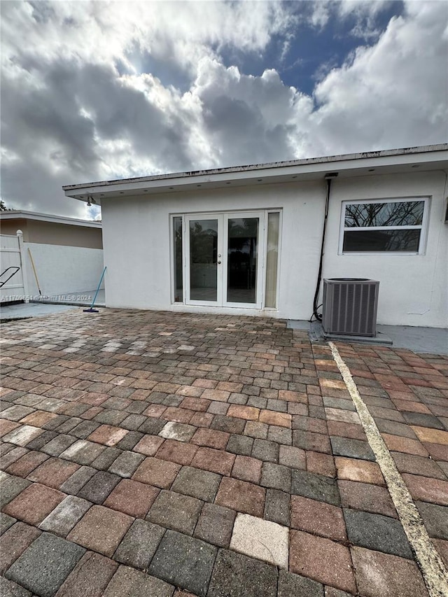 back of property featuring central air condition unit, french doors, and a patio