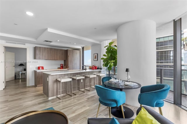 kitchen with a center island, a healthy amount of sunlight, a breakfast bar area, and light hardwood / wood-style flooring