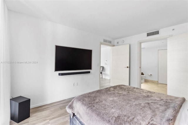 bedroom featuring ensuite bathroom and wood-type flooring