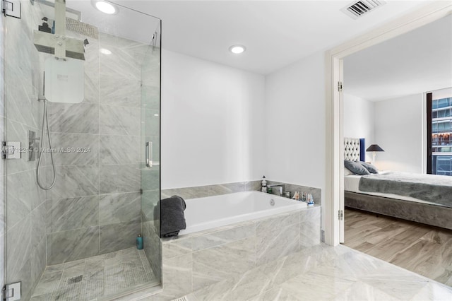 bathroom featuring plus walk in shower and wood-type flooring