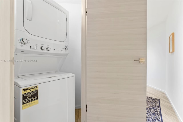 washroom featuring light hardwood / wood-style floors and stacked washer and clothes dryer