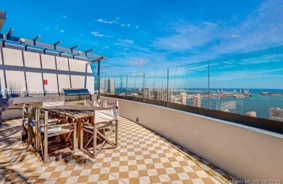 view of patio with a grill and a water view