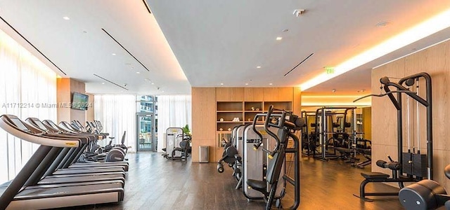 workout area featuring wood walls and dark hardwood / wood-style floors