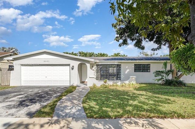 ranch-style home with a garage and a front lawn