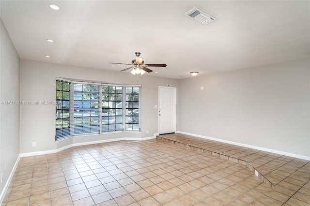 tiled spare room with ceiling fan