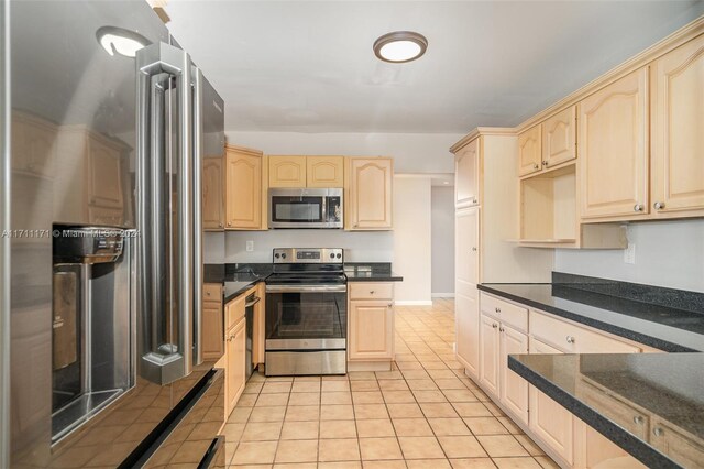 kitchen featuring light brown cabinets, light tile patterned flooring, and appliances with stainless steel finishes