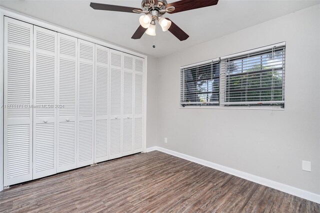 unfurnished bedroom with hardwood / wood-style floors, a closet, and ceiling fan