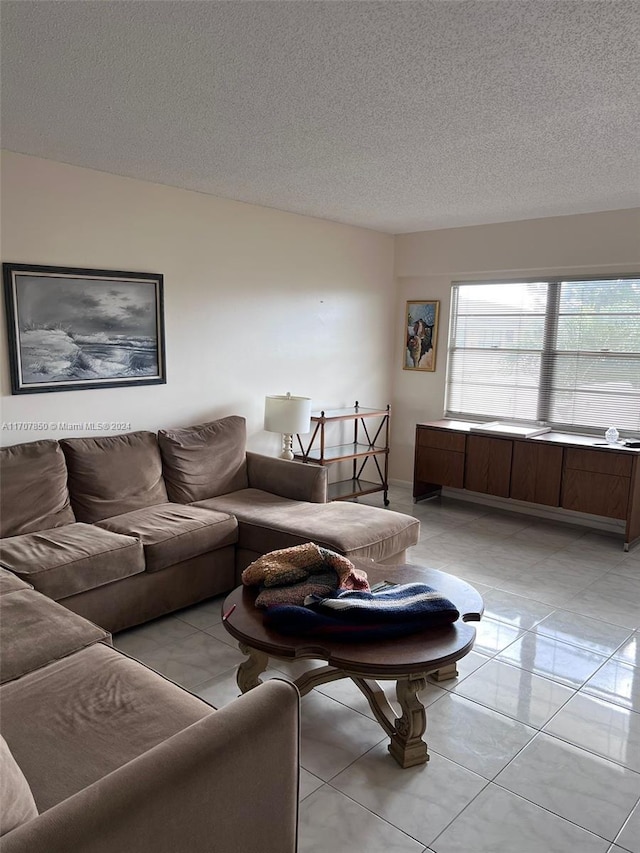 tiled living room featuring a textured ceiling