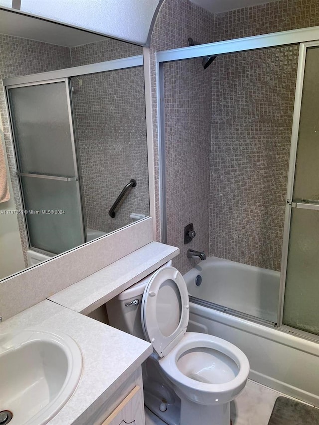 full bathroom with tile patterned flooring, vanity, toilet, and bath / shower combo with glass door