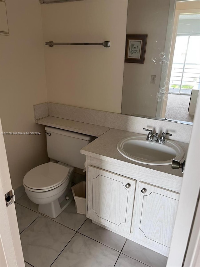 bathroom featuring tile patterned flooring, vanity, and toilet