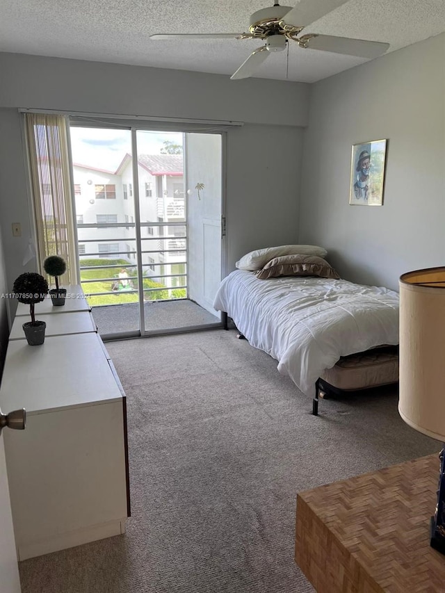 bedroom with access to exterior, ceiling fan, light colored carpet, and a textured ceiling