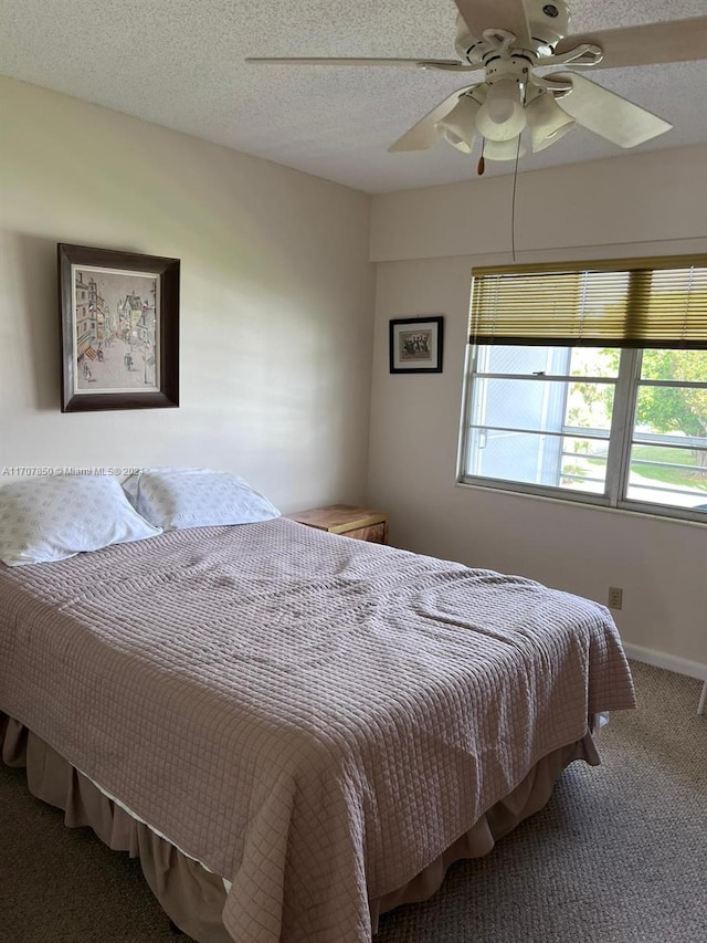 bedroom with a textured ceiling, carpet floors, and ceiling fan