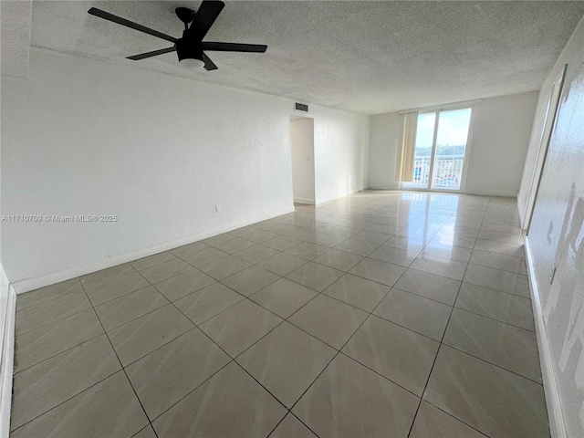 unfurnished room with ceiling fan, a textured ceiling, and light tile patterned floors