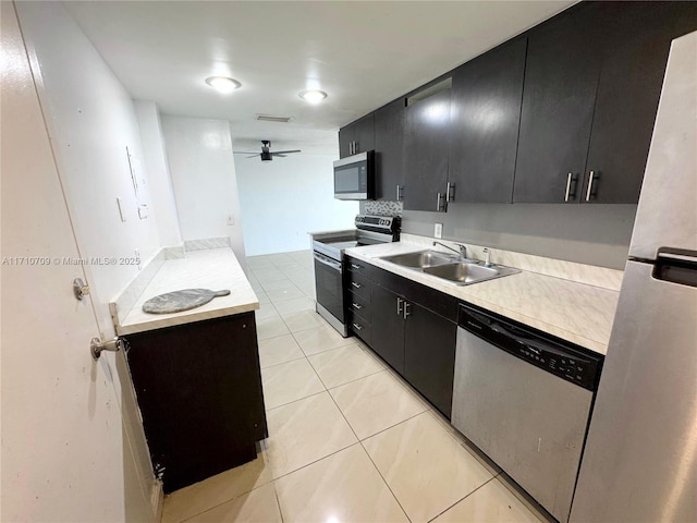 kitchen featuring sink, light tile patterned floors, ceiling fan, and appliances with stainless steel finishes