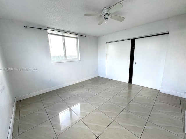 spare room featuring ceiling fan, a textured ceiling, and light tile patterned floors