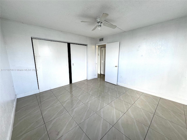 unfurnished bedroom featuring ceiling fan, a closet, and a textured ceiling