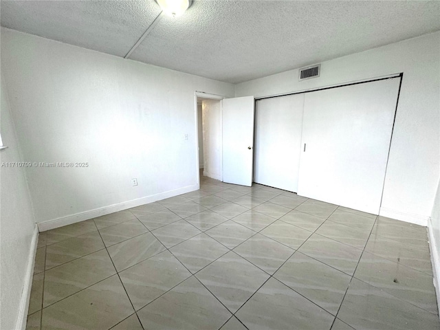 unfurnished bedroom featuring a textured ceiling and a closet