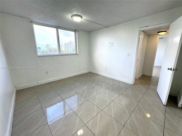 tiled spare room with a textured ceiling