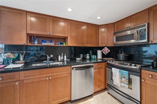 kitchen with stainless steel appliances, tasteful backsplash, dark stone counters, and sink