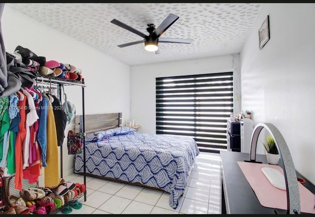 tiled bedroom featuring ceiling fan