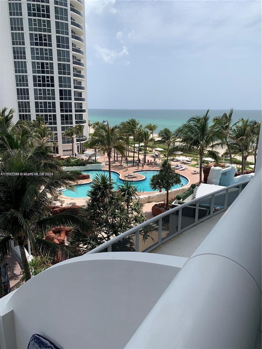 view of pool with a water view and a patio