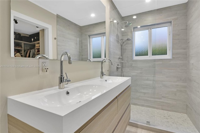 9008 Dickens Ave, Surfside, FL 33154 - bathroom featuring double vanity, a tile shower, a spacious closet, and recessed lighting