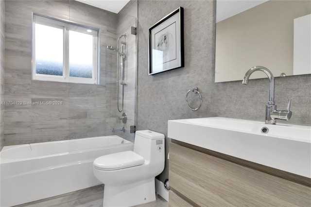 full bathroom featuring hardwood / wood-style floors, vanity, toilet, and tiled shower / bath