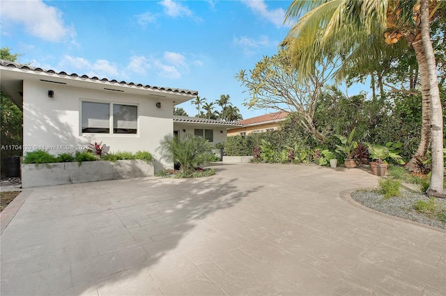 9008 Dickens Ave, Surfside, FL 33154 - view of property exterior featuring stucco siding, a patio, and a tile roof