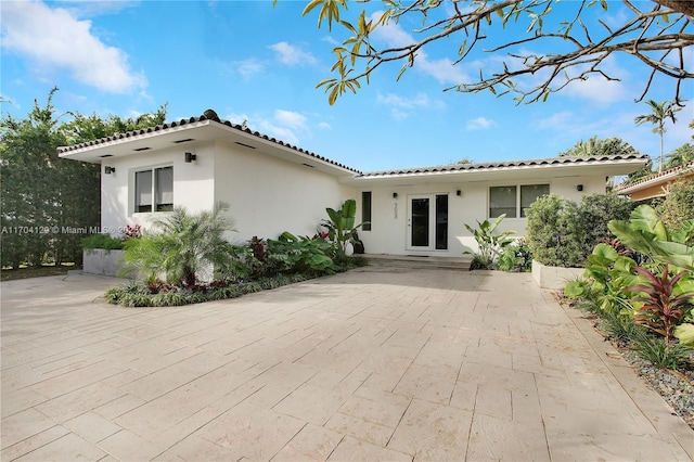 9008 Dickens Ave, Surfside, FL 33154 - view of front of home with stucco siding, a tile roof, and a patio