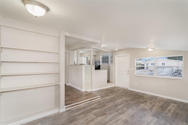 spare room with hardwood / wood-style flooring and lofted ceiling