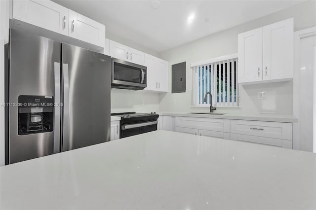 kitchen with sink, white cabinets, and appliances with stainless steel finishes