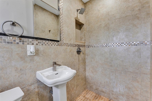 bathroom featuring a tile shower and toilet