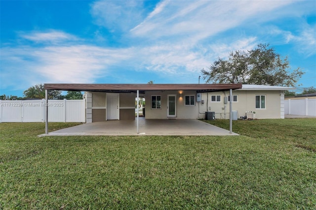 back of house featuring a patio area, a yard, and central AC