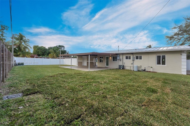 rear view of property featuring a lawn, a patio area, and cooling unit