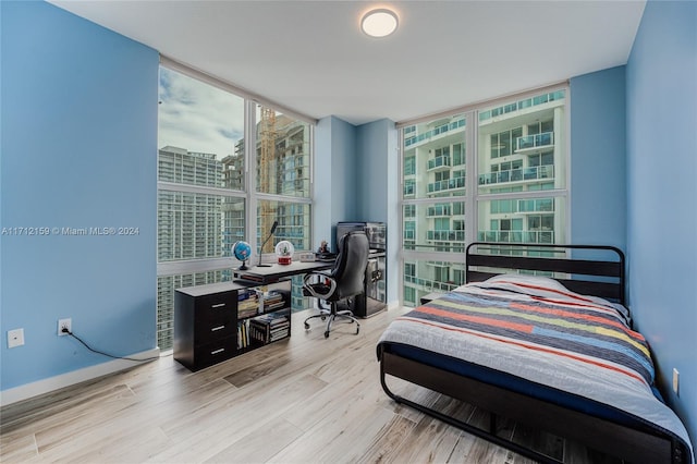 bedroom featuring expansive windows and light wood-type flooring