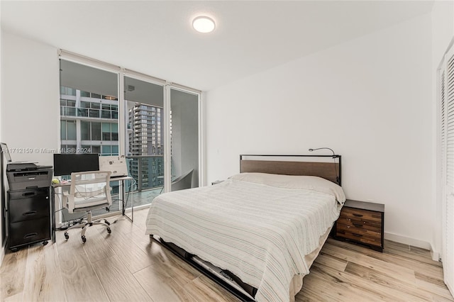 bedroom featuring light hardwood / wood-style flooring and floor to ceiling windows