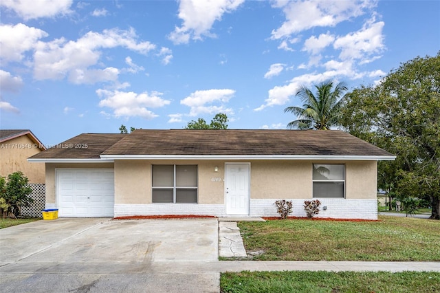 single story home with a garage and a front lawn