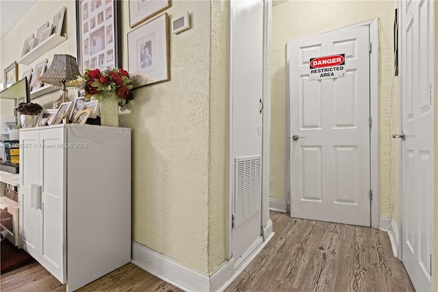 2716 Polk St, Hollywood, FL 33020 - hall with light wood-type flooring and a textured wall