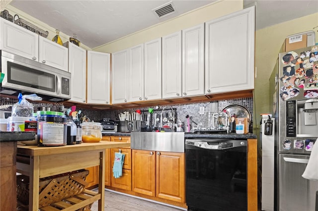 2716 Polk St, Hollywood, FL 33020 - kitchen with appliances with stainless steel finishes, decorative backsplash, light wood-type flooring, and white cabinetry