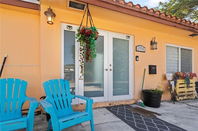 view of exterior entry with a patio and french doors