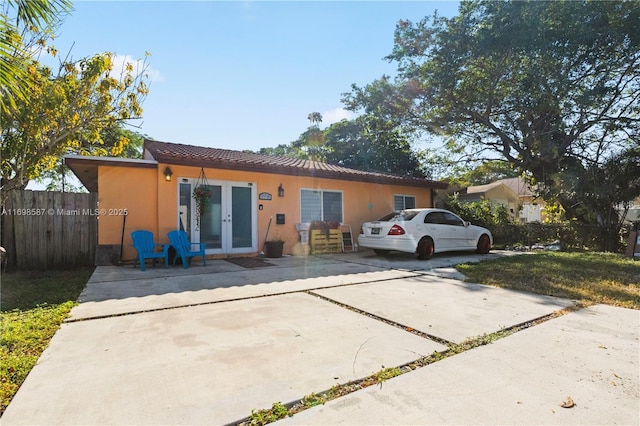 2716 Polk St, Hollywood, FL 33020 - view of front of house with french doors, a tile roof, stucco siding, and concrete driveway