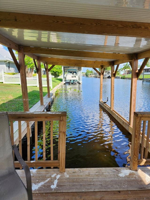 view of dock with a yard and a water view