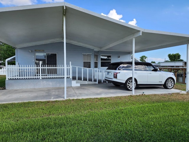 view of side of property with a carport and a lawn