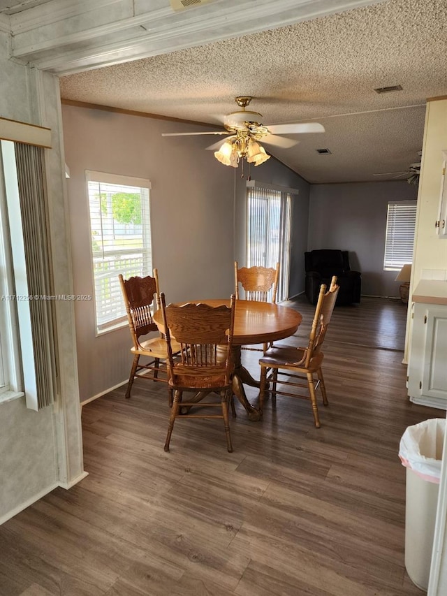 dining room with a textured ceiling, ceiling fan, plenty of natural light, and dark hardwood / wood-style floors