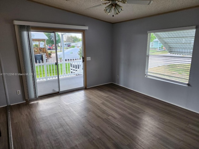 empty room with ceiling fan, dark hardwood / wood-style floors, lofted ceiling, a textured ceiling, and ornamental molding