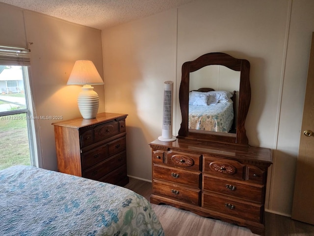 bedroom featuring hardwood / wood-style floors and a textured ceiling