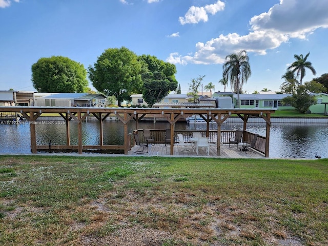 view of dock with a yard and a water view